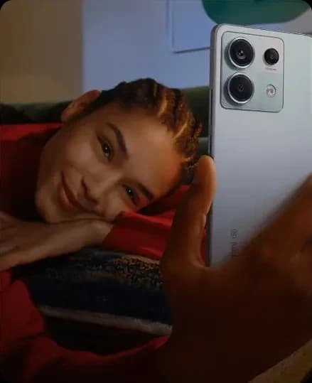 Mulher deitada sorrindo enquanto segura um smartphone Xiaomi